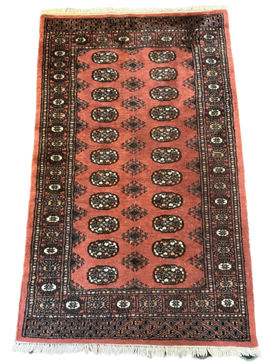 A red rug with black and brown designs on it.